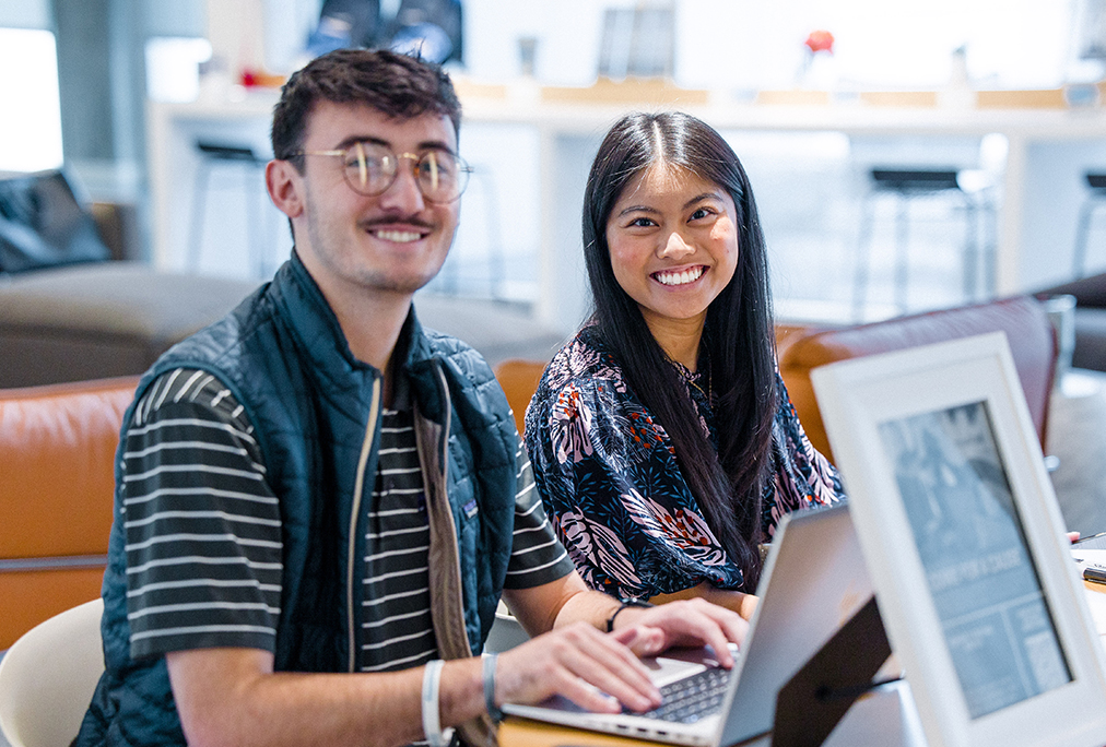 A young lady and a man working together on a laptop